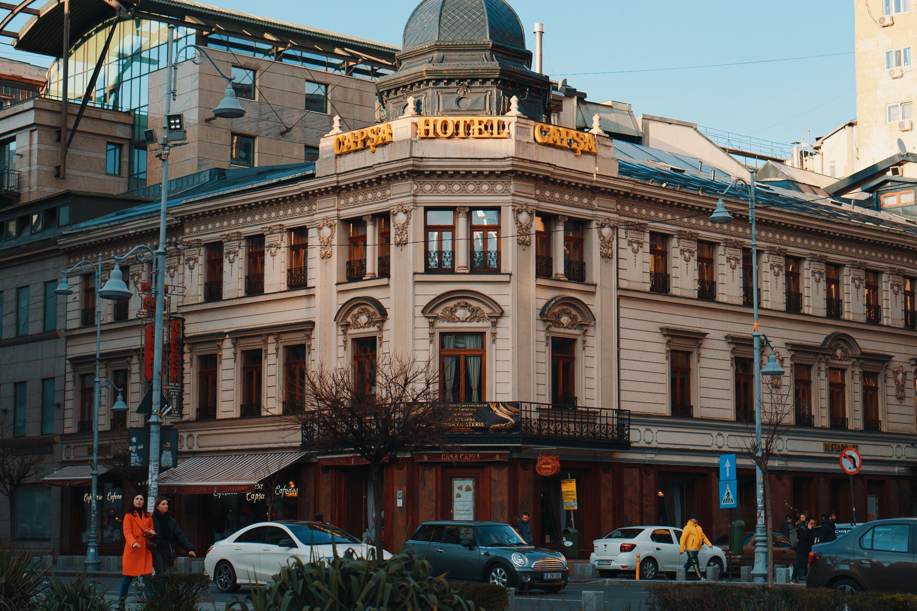 Beautiful historic hotel on a busy urban corner with cars and pedestrians, capturing city life.