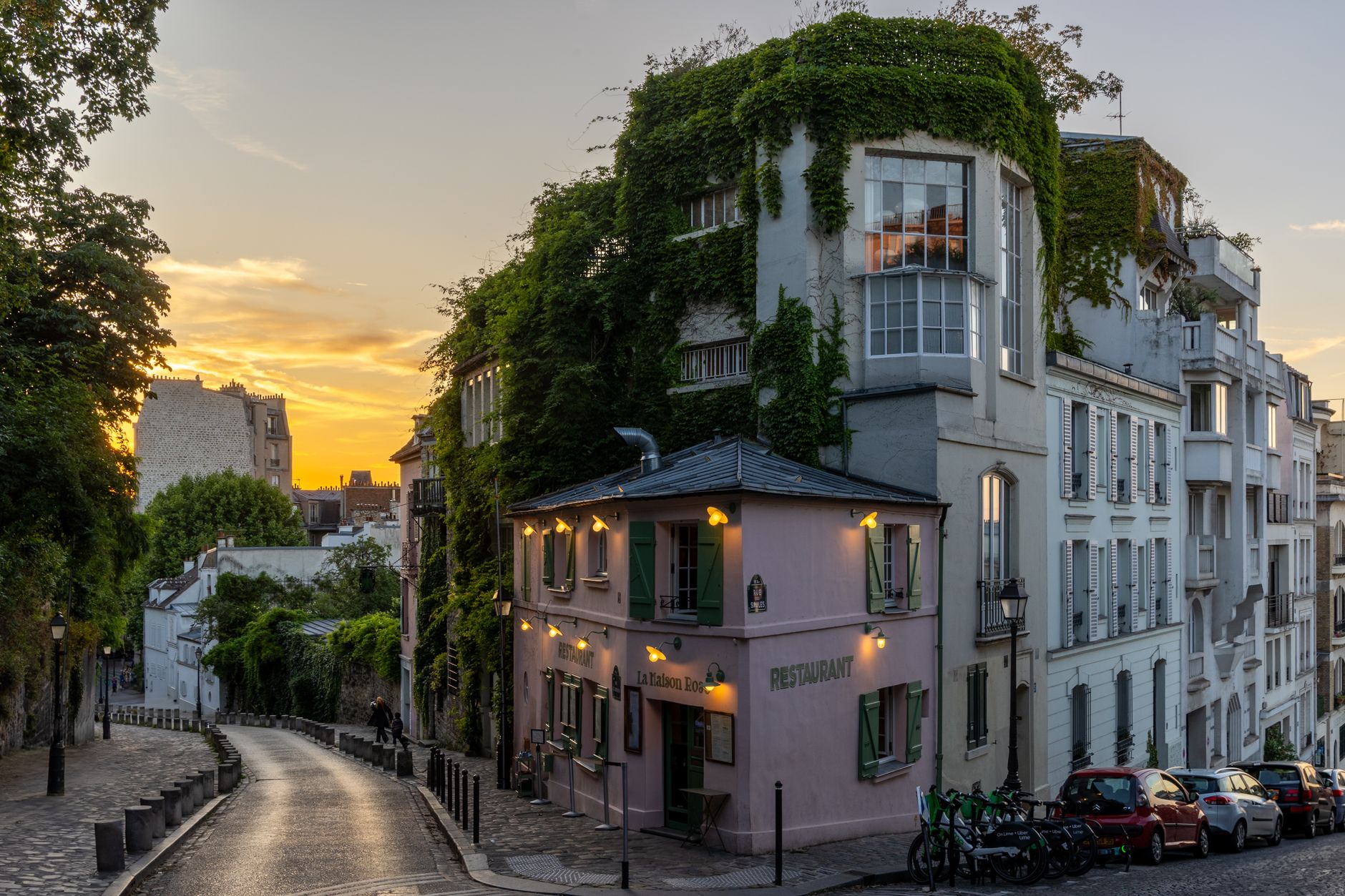 A serene street scene in Montmartre, Paris, showcasing a quaint restaurant during sunset.
